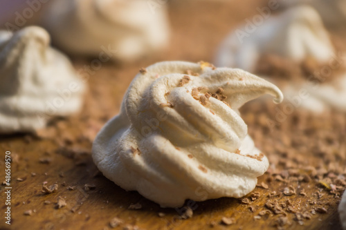 Delicious crispy homemade egg meringue sprinkled with grated dark chocolate  prepared with love on a wooden background  crunchy dessert for coffee or tea. 