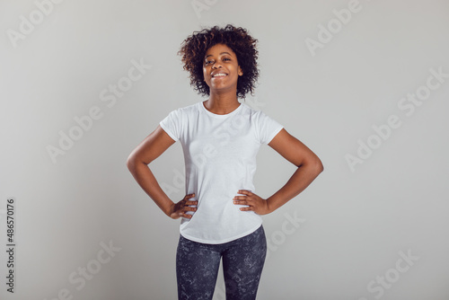 African american woman with puffy hair in a white t-shirt on a white background. Mock-up.