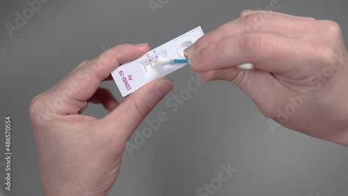 A person erases a positive coronavirus COVID-19 test result from a tester strip. The concept of falsifying results, understating epidemic statistics or pandemiс end.
