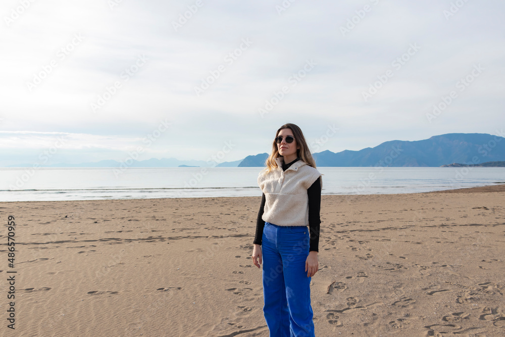 Lonely girl at beach in winter clothes. Dalyan, İztuzu Beach, Turkey.