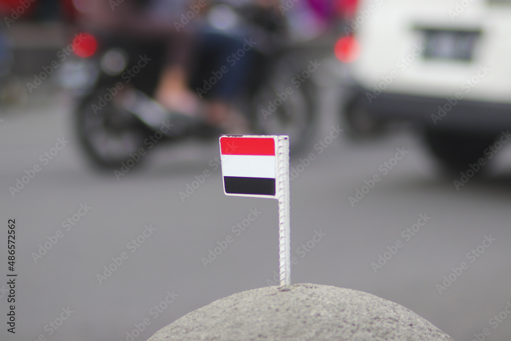 Yemen flag on a stone ball with blurred background in a sidewalk at Asia-Africa street in Bandung, West Java, Indonesia