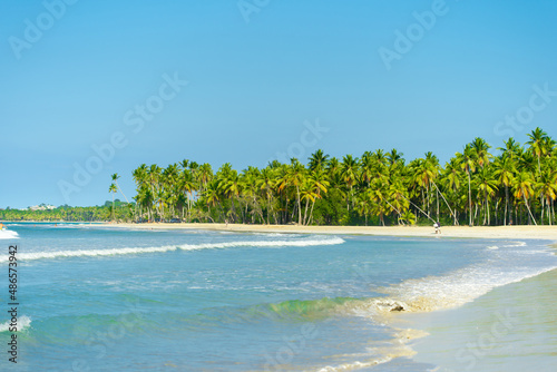 Bright colors of summer sunny Dominican beach. Relax in a Caribbean paradise. Beautiful tropical seascape. Blue cloudy sky over the turquoise ocean.