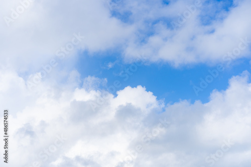 White cumulus clouds in a bright blue sky. Azure sky and open air. Clouds in the morning sunny transparent sky. Clear weather.