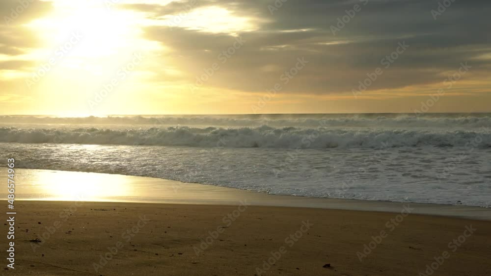 Sunset on the beach. A beautiful tranquil scene of empty sand beach, turquoise colored water, and cloudy sky Sunset on the beach. A beautiful tranquil scene of empty sand beach, turquoise colored water, and cloudy sky
