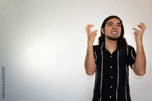 portrait of a very angry, furious and upset hispanic man on a white background