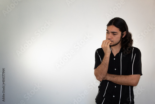 non binary hispanic man with a thoughtful attitude on a white background