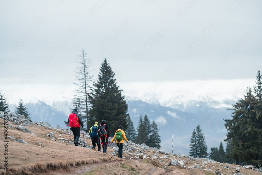 Group of mountaineers trek in winter scenery mountains. Team of hikers in hike in snowy mountains cold weather with backpack. People hiking on the beautiful snow mountains