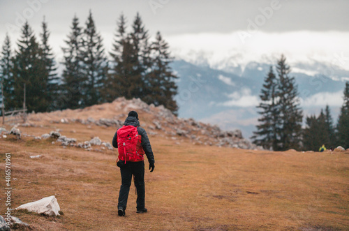 Man hiking in winter mountains with heavy backpack. Travel lifestyle wanderlust adventure winter vacations outdoor into the wild