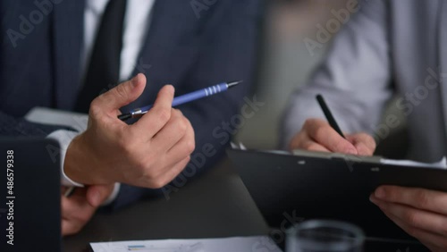 Businessman hands writing document analysing corporate report in company office. photo