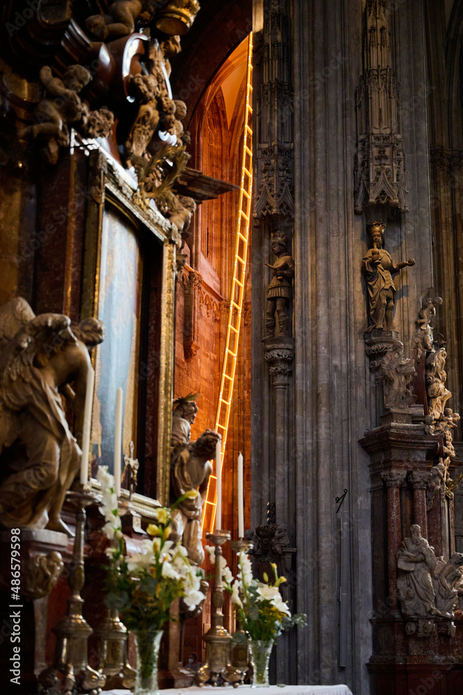 Altar in a Catholic Gothic church, with a ladder of light in the background. Looks majestic and divine.