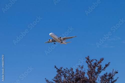 the plane is flying in the blue sky