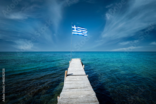 Greek flag on a beautiful sunny day at the end of a white wooden pier. Corfu Greece © aboutfoto