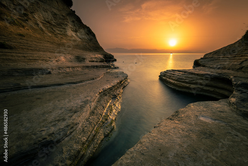 Spectacular sunrise over the beautiful little bay on Cape Drastis. Corfu Island Greece