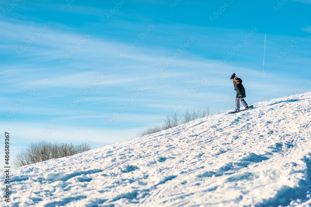 A kid snowboards down a hill