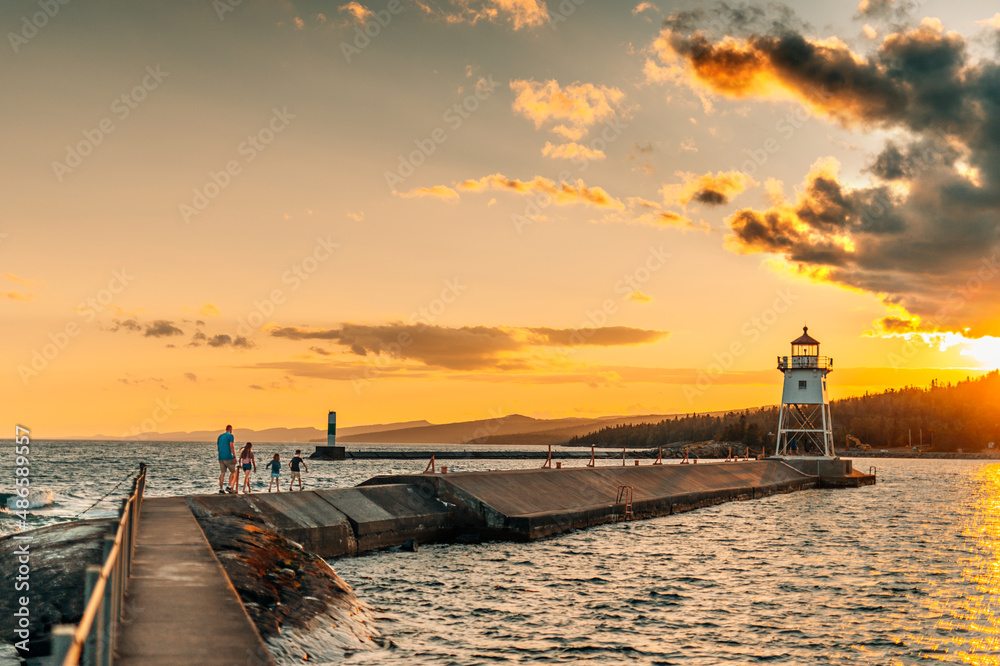 A family explores a pier near a lighthouse on the north shore of Lake Superior.