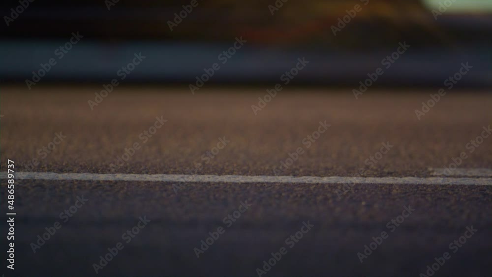 City carriageway marking on asphalt road closeup. Solid white line ending.