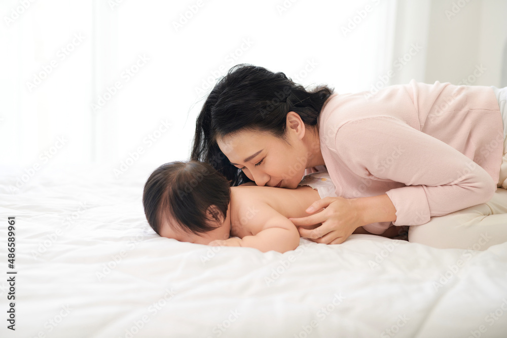 mother lies on the bed with the baby,