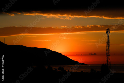 Sunset behind of mountain silhouette. orange, red sunset over the sea
