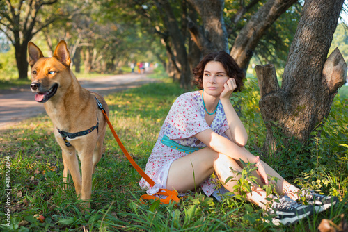 girl sitting on the ground with a dog
 photo