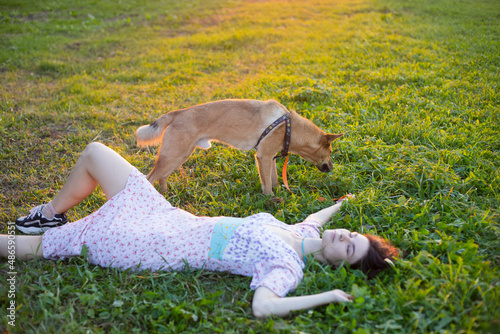 girl lying in the grass with a dog
