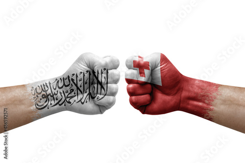 Two hands punch to each others on white background. Country flags painted fists, conflict crisis concept between afghanistan and tonga