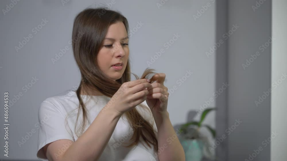 Young woman brushes her hair with a comb. Female is doing and styling her hair. Young woman brushes her hair with a comb. Female is doing and styling her hair.
