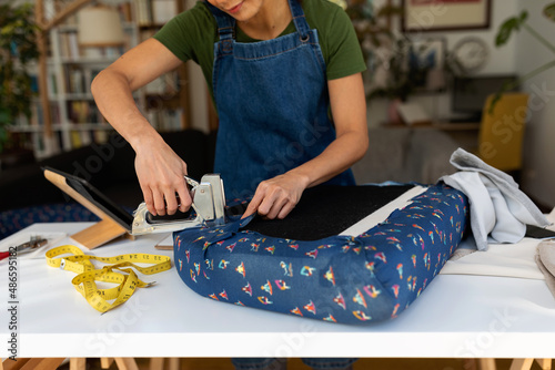 Woman upholstering comfortable seat at home