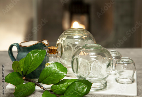 Cupping therapy glass cups at wellnes massage center, natural skin therapy for meridians of the body, suction stimulating flow of energy at treatment room spa center at blured background.