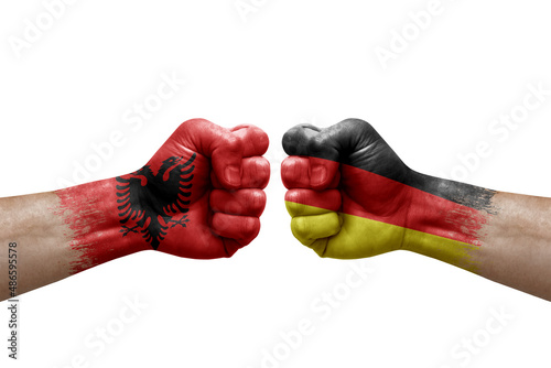 Two hands punch to each others on white background. Country flags painted fists, conflict crisis concept between albania and germany