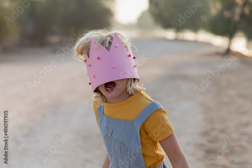 A little girl with a paper crown on her face photo