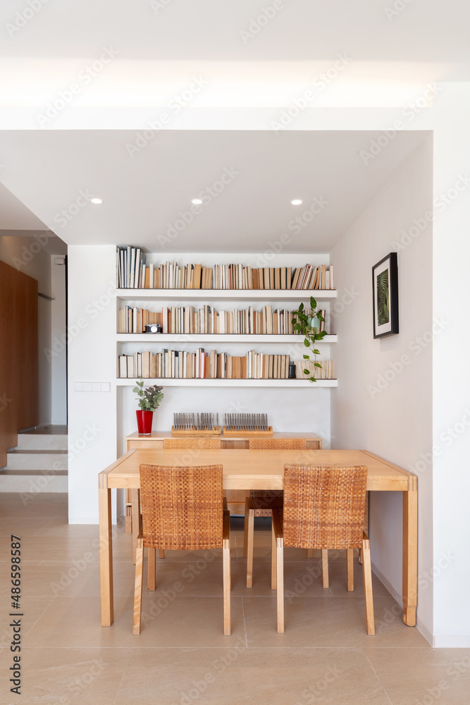 Wooden table and bookshelf in lounge Wooden table and bookshelf in lounge