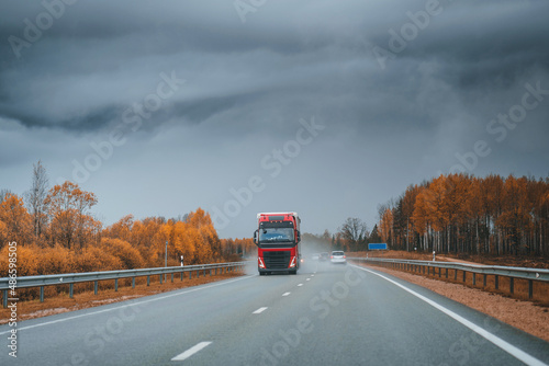 Red truck on highway on a stormy weather