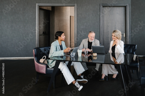 Positive multiracial coworkers talking in office