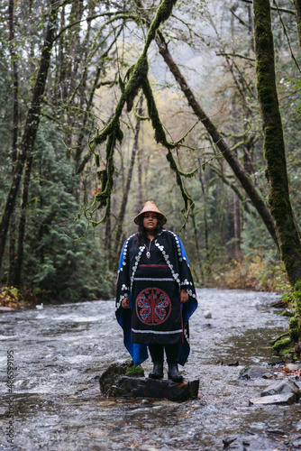 Woman standing in river wearing indigenous regalia