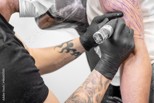 Salon tattoo. Close up of a Tattoo artist working. Tattoo artist make tattoo at the studio. High quality photography.