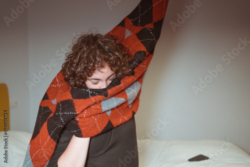 Teen girl taking off vintage sweater in bedroom  photo