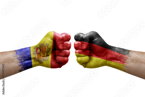 Two hands punch to each others on white background. Country flags painted fists  conflict crisis concept between andorra and germany
