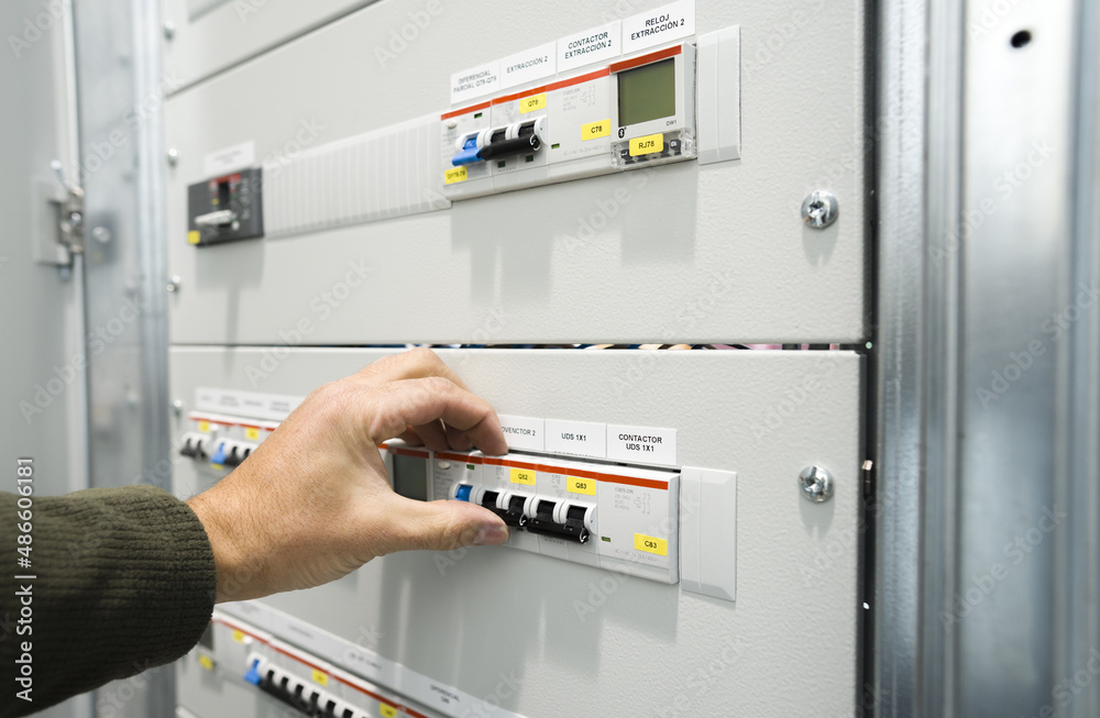 electrician operating circuit breaker on industrial electrical panel electrician operating circuit breaker on industrial electrical panel