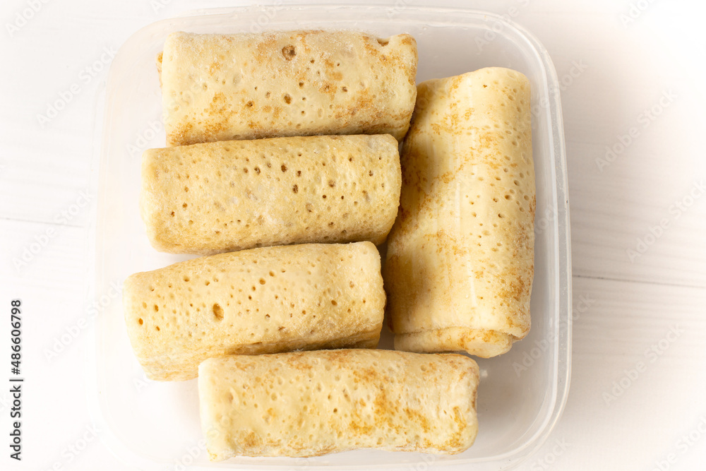 frozen pancakes in a container on a white table frozen pancakes in a container on a white table