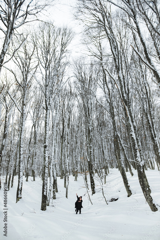 Young couple spending time outdoors in snowy forest