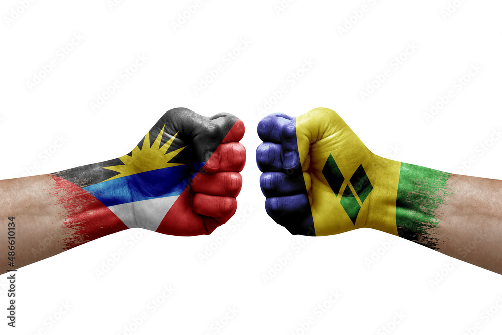 Two hands punch to each others on white background. Country flags painted fists, conflict crisis concept between antigua and barbuda and saint vincent and the grenadines