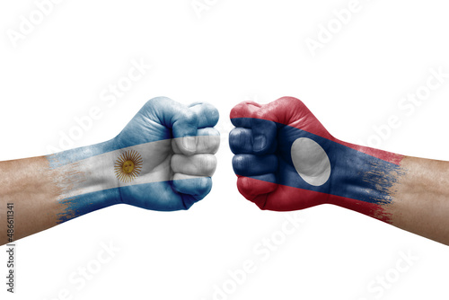 Two hands punch to each others on white background. Country flags painted fists, conflict crisis concept between argentina and laos
