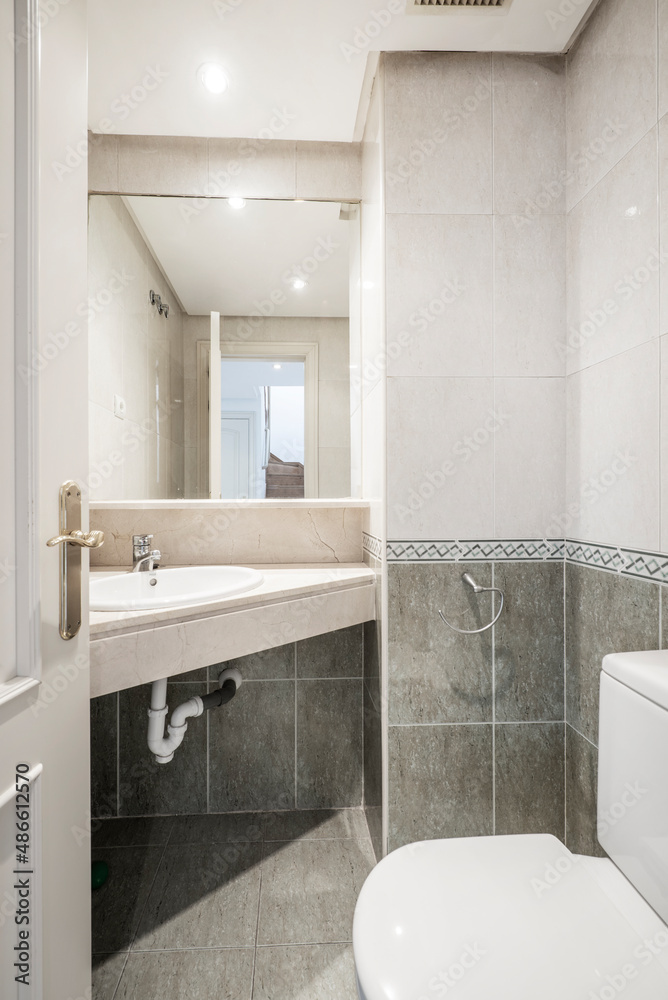 Bathroom with corner marble top and half green tiles with border and ...
