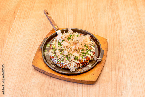 Okonomiyaki is a Japanese food that consists of a dough with ingredients cooked on the grill. The word okonomiyaki is made up of the honorifics o, konomi, and yaki, meaning "cooked to your liking."