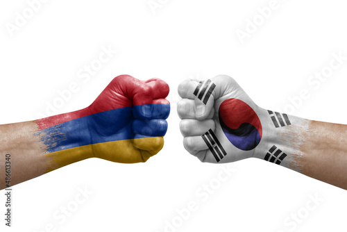 Two hands punch to each others on white background. Country flags painted fists, conflict crisis concept between armenia and south korea