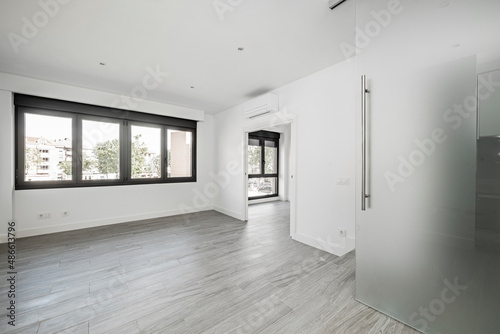 Wallpaper Mural Empty living room in a loft with large black aluminum windows with gray wood-like ceramic floors and opaque glass sliding door Torontodigital.ca
