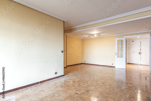 Living room with nooks and crannies and French oak parquet floors with white lacquered carpentry doors and mahogany-colored skirting boards