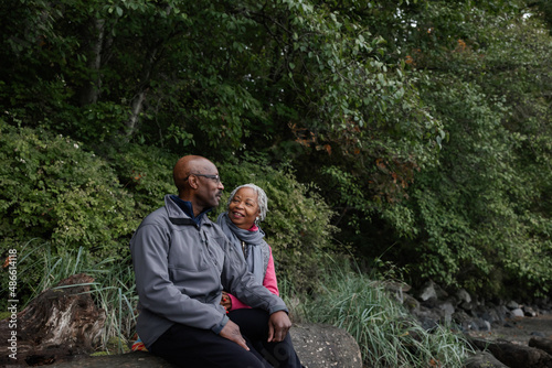 Older couple sitting together outside in nature.