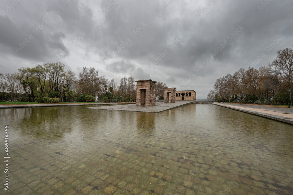 Obraz premium Temple of Debod in the Parque del Oeste in the middle of an artificial lagoon on a cloudy winter day