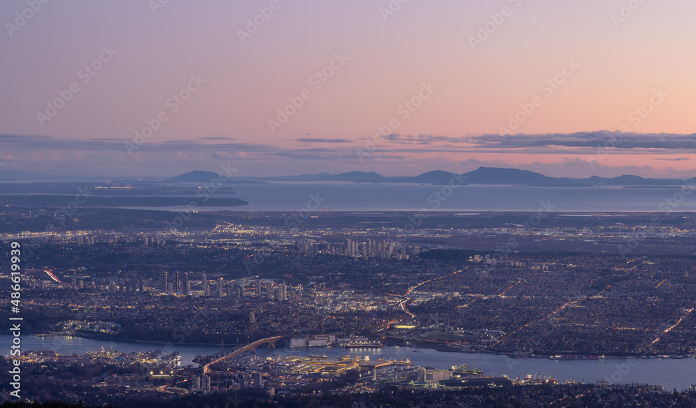 Vancouver Cityscape, British Columbia, Canada on the West Coast of Pacific Ocean. Aerial Panoramic View at Sunset Twilight. Modern City lights. Taken from Grouse Mountain.